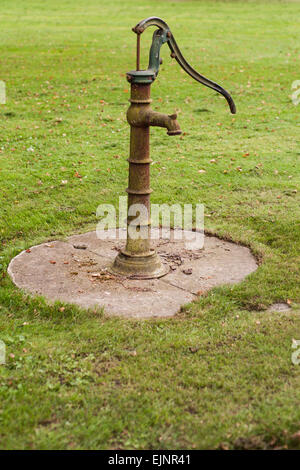 Retro-alte rostige Wasserpumpe auf Rasen Stockfoto