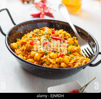 indischer Chickencurry mit Erbsen und Paprika auf Pfanne Stockfoto
