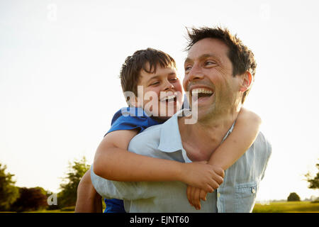 Ein Vater mit seinem Sohn eine Huckepack. Stockfoto
