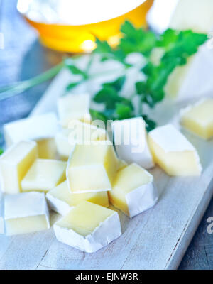 Camembert Käse an Bord und auf einem Tisch Stockfoto