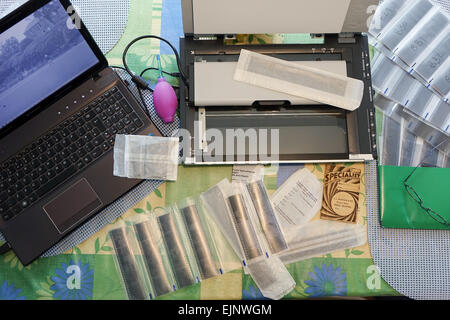 Laptop-Film-Scanner und negative auf einem Tisch wird gescannt und auf einen Computer für den Druck übertragen. Stockfoto