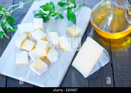 Camembert Käse an Bord und auf einem Tisch Stockfoto