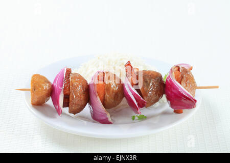 Speck und Kartoffel-Spieß mit weißem Reis Stockfoto