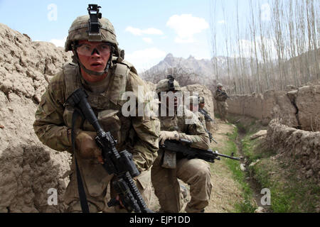 US Army Pfc. Joshua Clark und Spc. Saikan Corbitt mit 4th Brigade Combat Team, 10th Mountain Division, 30. Infanterie-Regiment, 2. Bataillon, 1. Zug, Bravo Kompanie bewegen hinter Lehmwänden, um einen feindlichen Scharfschützen während Betrieb Charkh Restaurierung, Charkh District, Provinz Logar, Afghanistan, April 5 übernehmen. Stockfoto