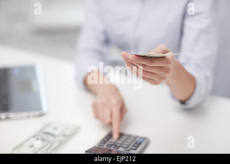 Nahaufnahme von Frau Geldzählen mit Taschenrechner Stockfoto