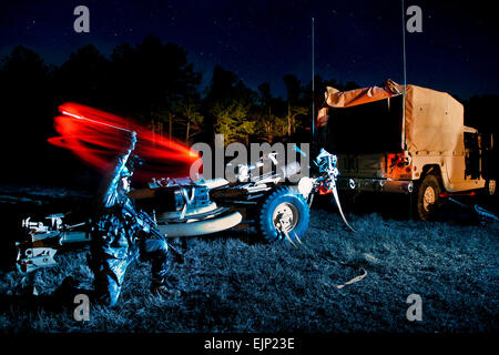 Sgt. Orlando Garcia schwingt eine rote chemische Licht, Kollegen Artilleristen auf seine Waffe zu sammeln, während des Trainings 10. Februar 2011, in Vorbereitung für eine große 82nd Airborne Division nächtliche Luft Übung in Fort Bragg, N.C.  Der Soldat-Einheit, 3. Bataillon, 319th Airborne Field Artillery Regiment, 1st Brigade Combat Team, wird Luft-zwei M119A2 105 mm Haubitzen aus einer c-17 Flugzeug zusammen mit der Pistole Mannschaften mit dem Ziel der Vorbereitung eine der Waffen innerhalb von 25 Minuten die erste Fallschirmjäger Ausfahrt Feuer Tropfen.  Sgt. Michael J. MacLeod Stockfoto