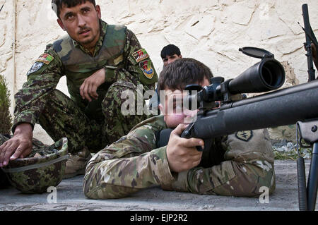 US Army Spc. Joshua M. McLay, ein Infanterie-Kader benannt-Schütze aus Cassville, Mo., Firma A, 2. Bataillon, 35. Infanterie-Regiment, Task Force Kakteen, 3rd Brigade Combat Team, 25. Infanterie-Division, Task Force Bronco zugewiesen Afghan National Army Soldaten zeigt, wie man richtig Sicht eine M24-Gewehr während Betrieb Steinstufen auf Nangalam Basis im Osten Afghanistans Provinz Kunar, Mai 31. Soldaten ausgebildet, die ANA auf verschiedenen Treffsicherheit und Waffentraining in der vier-Tage-Betrieb. Stockfoto