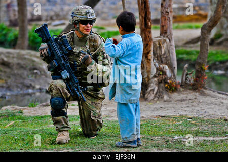 US-Armee Pfc. Jared Baughn spricht mit einem afghanischen Kind während einer Patrouille in der Nähe von Combat Outpost Terezayi, April 10.  US Army Spc. Eric James Estrada Stockfoto