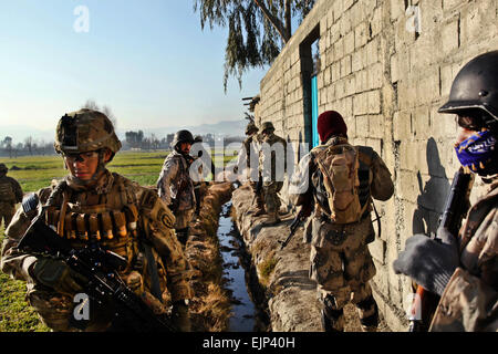 US-Armee Pfc. Eric Guzman, 1. Bataillon, 501. Infanterie-Regiment, 4. Airborne Brigade Combat Team, 25. Infanterie-Division, Spartan Task Force bietet Sicherheit neben afghanischen Grenze Polizisten während Patrouillen eine Dorf in Khowst Provinz, Afghanistan, 18. Januar 2012. Stockfoto