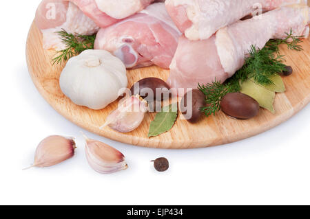 Rohe Hähnchenkeulen mit Oliven und Knoblauch auf einem Holzbrett Stockfoto