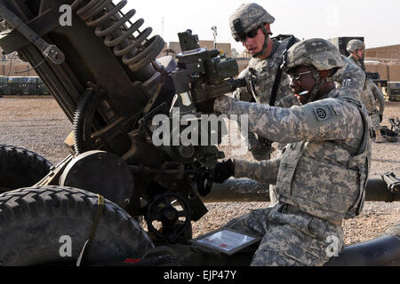 US Army Staff Sgt Samuel Feldman überwacht wie Sgt. Clarence Robinson die Erhebung einer Haubitze in Rezertifizierung Ausbildung bei Camp Ramadi, Irak, 31. Juli 2011 wirft. Alle 16 Mannschaften, der 82nd Airborne Division 2nd Battalion, 319th Airborne Field Artillery Regiment, 2. beraten und unterstützen Brigade zugewiesen muss alle sechs Monate Rezertifizierung, um ihre Fähigkeiten scharf zu halten. Feldman ist ein Abteilungsleiter und Robinson ist ein Schütze. US Army Spc. Kissta Feldner Stockfoto