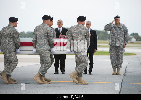 US-Verteidigungsminister Chuck Hagel rendert Auszeichnung als ein Carry-Team trägt das Verteilergetriebe mit den sterblichen Überresten der Armee Pfc. Cody Patterson, die in Afghanistan, während eine würdige Übertragung auf der Dover Air Force Base in Dover, Delaware, 9. Oktober 2013 gestorben. Offizielle Sgt. Aaron Hostutler US Marinecorps veröffentlicht Stockfoto