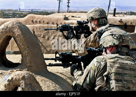 US Army Spc Matthew Newcomb links und US-Armee Pfc. Brandon Hobgood scannen ihre Sektoren von einem Aussichtspunkt auf dem Dach in Arezo Dorf, Okt. 31. Die Soldaten sind Mitglieder von Fort Knox, Kentucky-basierte 2nd Platoon, Firma D, 2. Bataillon, 2. Infanterie-Regiment, 3rd Brigade Combat Team, 1st Infantry Division, Task Force Duke, und waren in Arezo Dorf im Rahmen einer humanitären Hilfe Mission unter der Leitung von Afghan National Army Elemente, Stifte, Schule Rucksäcke, Radios und Decken an Kinder und andere Dorfbewohner zu verteilen. Stockfoto