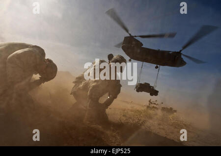 US Army Staff Sgt Hector Hoyas Recht, aerial Delivery Bereich Service Abteilung Instruktor und Air Force Senior Airman Matthew Phillips, Abkehr von der Rotor-Wäsche als ein Nevada National Guard CH-47 Chinook Hubschrauber mit einem Humvee in Nellis Air Force Base, Nevada, beim Sling-Last Training am 15. April 2011 startet.   Techn. Sgt. Michael R. Holzworth, US Air Force.  Veröffentlicht Stockfoto