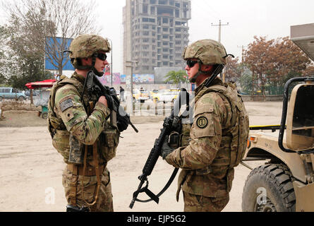 Task Force Spartan 3 Soldat Armee Spc. Daniel Fowler richtige bietet Sicherheit für sein Team während afghanische Polizei Offiziere Routine Fahrzeugprüfungen an Freiheit Kreis im Herzen der Innenstadt von Kabul durchzuführen. Spartan 3 ist ein 15-köpfiges Team, die als Bekämpfung Berater von ANP Offiziere an mehr als 50 verschiedenen Checkpoints innerhalb 5 Kabul Polizeibezirke in der dicht besiedelten Stadt dienen. Stockfoto