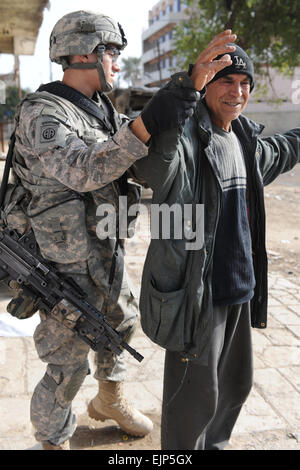 US-Soldat von C Company, 2. Bataillon, 505. Fallschirm Infanterie-Regiment, 3rd Brigade Combat Team, 82nd Airborne Division, sucht irakischen Zivilisten im östlichen Bagdad, Irak, am 31. Januar 2009. Dieser Soldat stellt sicher, dass die zivile ist nicht alles tragen, die anderen Schaden zufügen könnten, während sie stimmen. Stockfoto