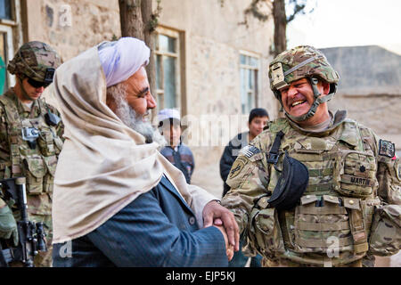 US Army Lieutenant Colonel Mark Martin, Recht, zivile Angelegenheiten Teamleiter für provinzielle Rekonstruktion Team PRT Farah, schüttelt die Hand und lacht mit Mawlawi Guhlam M. Ruhaani, Direktor des Hajj und die Kapitallebensversicherung, am Ende ein Schlüssel Führer Engagement in Farah Stadt, Dez. 29.  PRT Farah Mission ist, trainieren, beraten und unterstützen afghanische Staats-und Regierungschefs bei den Stadtwerken, Kreis und Landesebene in der Provinz Farah, Afghanistan.  Ihre zivile Militär-Team besteht aus Mitgliedern der US-Marine, US Army, US Department of State und der Agentur für internationale Entwicklung USAID.   HMC Josh Ive Stockfoto