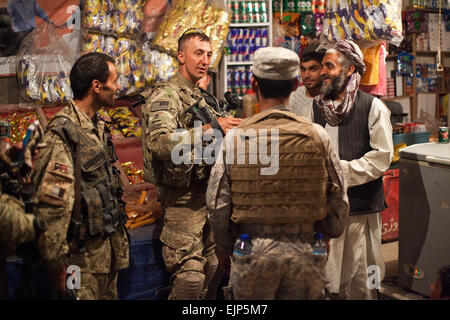 Eine afghanische nationale zivile Ordnung Polizist spricht zu einem örtlichen Ladenbesitzer während einer Mission unter der Leitung von US-Armee Soldaten zugewiesen, Alpha Company, 5. Staffel, 1. Kavallerie-Regiment 25. Infanterie-Division, die Straßen außerhalb bekämpfen Betrieb Post 8-1, in der Innenstadt von Stadt Kandahar, Afghanistan, 29.Mai patrouillieren. Das Ziel der Mission ist es, taktische Kontrollpunkte eingerichtet, Fahrzeuge/Insassen suchen und Atmosphären aus der allgemeinen Bevölkerung zu sammeln. Stockfoto