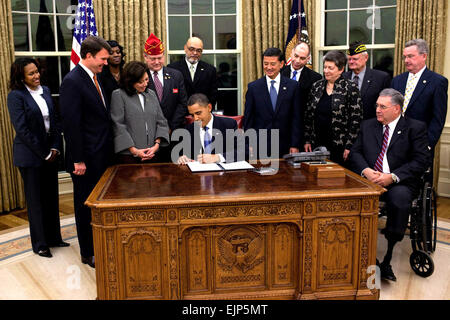 Präsident Barack Obama unterzeichnet eine Ausführungsverordnung auf die Beschäftigung der Veteranen in der Bundesregierung, 9. November 2009, im Oval Office im Weißen Haus. Weiße Haus Pete Souza Stockfoto