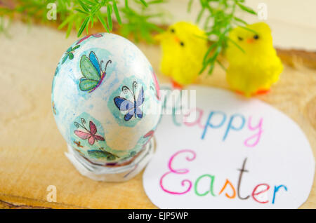 Handbemalte Ostereier auf einem Holztisch mit Stroh dekoriert Stockfoto