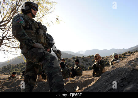 US Army Special Forces Soldaten, von Special Operations Task Force East, Uhren afghanischen Commandos aus 2. Commando Kandak während Patrouillen ein Dorf im Distrikt Dand Patan während einer Operation. Die drei-Tages-Betrieb wurde durchgeführt, um die Regierung der islamischen Republik Afghanistan Präsenz in abgelegenen Dörfern entlang der Grenze Afghanistan und Pakistan in Paktia Provinz, Afghanistan, 30. November zu verstärken. Stockfoto