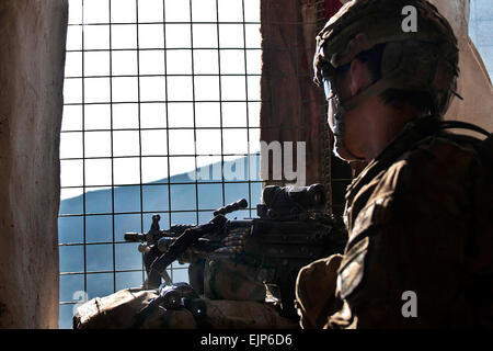 Während einer kurzen Pause zum Essen und ausruhen steht US Army Pfc. Chris J. Nielsen, ein M249 Squad automatische Waffe Kanonier aus Huntington Beach, Kalifornien, Unternehmen B, 1. Bataillon, 327th Infanterie-Regiment, Task Force Bulldog zugewiesen Wache am Fenster bei gemeinsamen clearing Operationen im Pech River Valley im Osten Afghanistans Provinz Kunar 25 November.  US Army Staff Sgt Mark Burrell, Task Force Bastogne Public Affairs Stockfoto