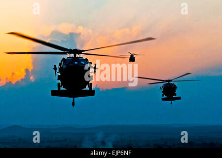 Wie die Sonne-Köpfe auf den Horizont, zwei UH-60 Black Hawks und ein CH-47 Chinook bereiten Sie landen am vorwärts Operating Base Connolly US-Verteidigungsminister Robert M. Gates abholen, nachdem er Truppen auf Forward Operating Base Connolly in Ost-Afghanistan Dez. 7 besucht.  US Army Staff Sgt Mark Burrell, Task Force Bastogne Public Affairs Stockfoto