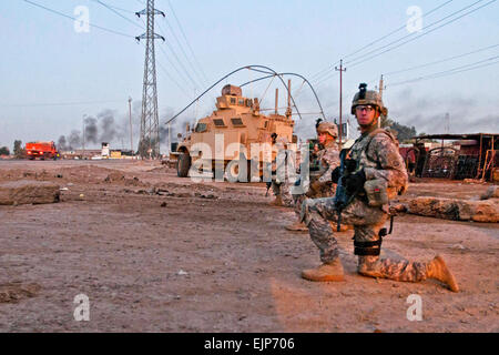 Militär-Polizisten, die 2. Brigade spezielle Truppen Bataillon, 2. Brigade, 82nd Airborne Division zugewiesen nehmen eine Knie während einer abgesessene Patrouille entlang einer Straße außerhalb des Camp Taji, Irak, Dez. 2. Die MPs ausgerollt lange vor Sonnenaufgang Straßen außerhalb des Lagers für die Sicherheit der 2/82 Konvois Reisen durch das Gebiet von Bagdad zu patrouillieren. Die 2. Brigade ist die letzte Brigade in Bagdad und fördert den Rückzug der US-Streitkräfte aus dem Irak. Stockfoto