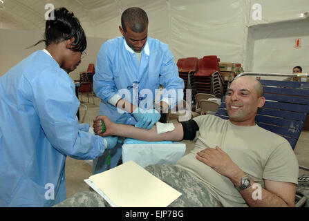 Sabrina Thomas, ein Zivilist, arbeiten mit dem Robertson Blood Donor Center unterstützt Sgt. Marcus Haynes, 345. Combat Support Hospital, mit Zeichnung einen Pint Blut von Sgt. Michael Honore, ein Beobachter Controller/Trainer mit dem 120. Infanterie-Brigade, erste Armee Division West.  Haynes, aus Arlington, Texas, wird zum dritten Mal bereitstellen, aber dies ist seine erste Tour mit dem 345th. Stockfoto