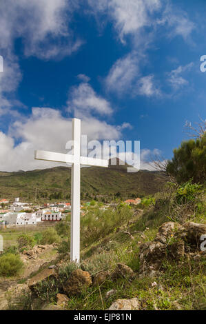 Sommer-Bergblick mit weißen Holzkreuz. Es steht auf Hügel in Santiago del Teide, Teneriffa, Spanien. Stockfoto