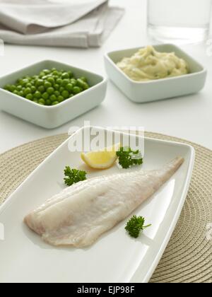 Vergoldete Mahlzeit des plain Filet vom Schellfisch Fisch mit Zitrone Petersilie Erbsen-Kartoffelpüree Stockfoto