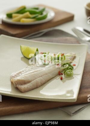 Vergoldete Mahlzeit des plain Filet vom Fisch mit Limette Petersilie locken Frühlingszwiebeln und gehackte Chilibohnen und Babymais Stockfoto