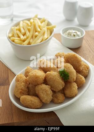 Panierter Fisch Nuggets Chips separaten Schüsseln Tartare Sauce Menage set Glas water.wooden board Stockfoto