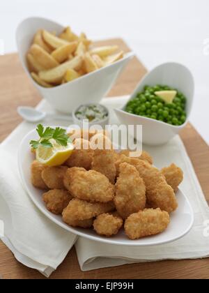 Panierte Fisch Nuggets Pommes Frites und Erbsen in separaten Schüsseln, Holzbrett Stockfoto