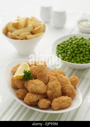 Panierter Fisch Goujons, Zitrone und Petersilie in einer Schüssel plus Schalen der Haut auf Chips, rustikalen Stil, Markerbsen, Töpfchen Remoulade Stockfoto