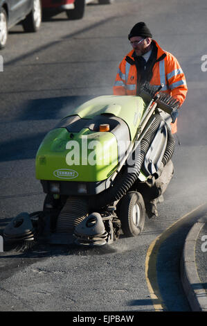 Ein Mann von einer lokalen Behörde arbeiten fegen der Straße mit einem Industriestaubsauger, UK beschäftigt Stockfoto