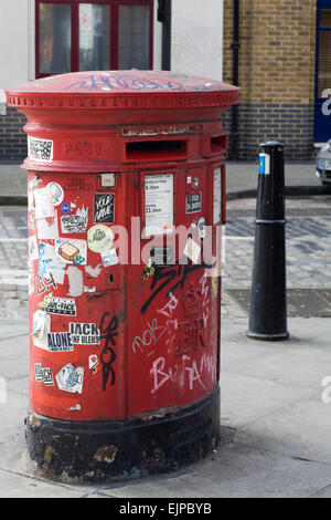 Graffiti und Aufkleber auf einem alten Briefkasten in London England Stockfoto