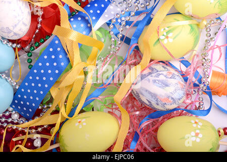 Ostern-Hintergrund mit Eiern, Bändern und Frühlingsdekoration Stockfoto