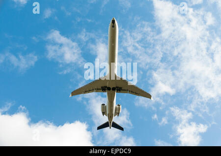 Blick vom unter geht ein Flugzeug der Lufthansa Fokker 100 als es über Kopf Stockfoto