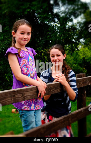 Zwei glückliche Schwestern Spaß in einem Garten hinter dem Haus in North County Dublin Irland. Stockfoto