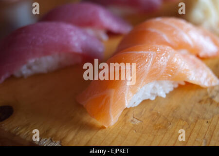 Traditionelle Sake (Lachs) Nigiri Sushi rote Maguro (Thunfisch) Nigiri Sushi auf ein Schneidbrett aus Holz. Stockfoto