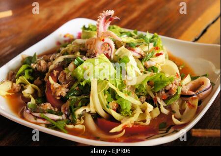 Thai Meeresfrüchtesalat mit Tintenfisch über grünes Blatt Stockfoto