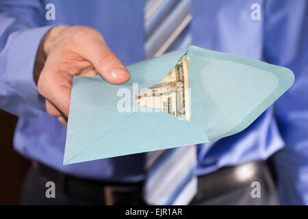 Mann in einem blauen Shirt, Bestechung in einem blauen Umschlag Stockfoto