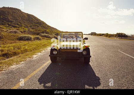 Liebespaar fahren in einem kleinen offenen gekrönt Fahrzeug an einem Sommertag. Junges Paar auf Fahrt in einem Auto. Stockfoto