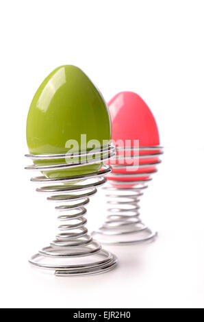 Grün und rosa Osterei in einen Eierbecher auf weißem Hintergrund Stockfoto