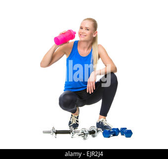 blonde Frau trägt Fitnesskleidung und trinken nach dem Training mit Gewichten Stockfoto