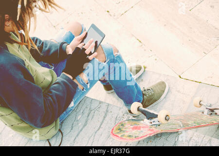 Abgeschnitten Bild männlichen Freiberufler mit Dreadlocks sitzen mit digital-Tablette eingeben warm Nachrichtenfilter angewendet Stockfoto