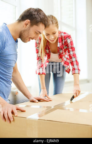 lächelnde paar Eröffnung großer Karton Stockfoto