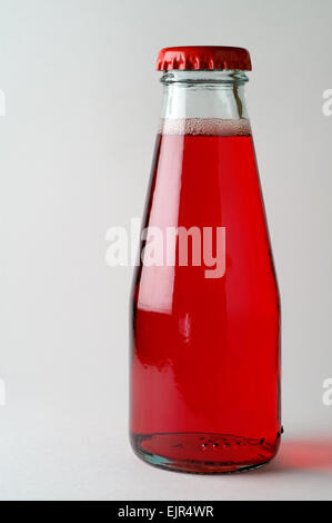 Rotes Getränk mit Luftblasen in der Flasche mit roten Kronkorken verschlossen Stockfoto