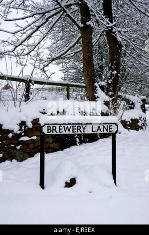 "Brauerei Lane" schneebedeckte Straßenschild in Cotswold Dorf von Hook Norton Stockfoto